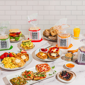Table with various breakfast items including muffins, sandwiches, and fruits with 'Dam Good English Muffins' packaging.