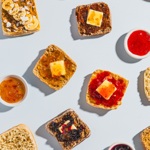 Dam Good English Muffins with various spreads on a light blue background