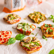 Load image into Gallery viewer, Small Dam Good English Muffin pizzas with various toppings on a white surface
